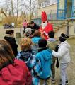 Der Nikolaus und seine Helferinnen verteilen Süßigkeiten und Nüsse an die Schüler/-innen. 